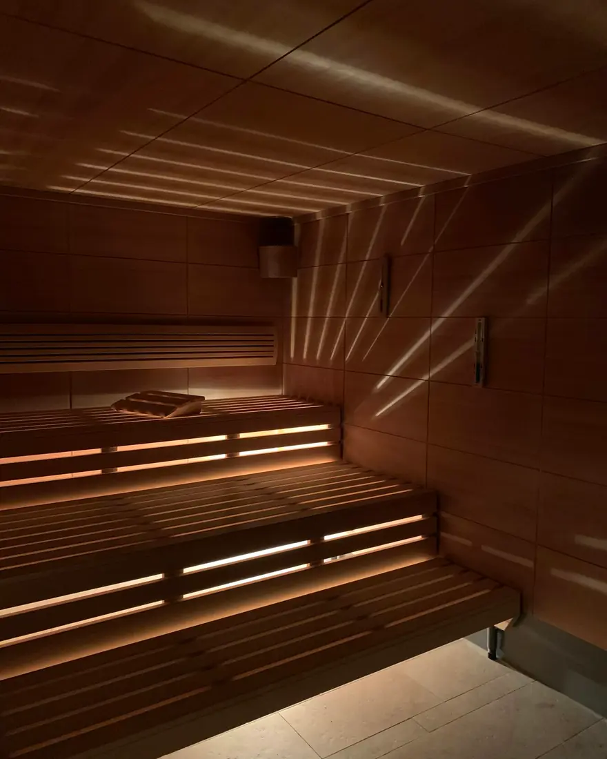 Warm light across the benches of an infrared sauna cabin
